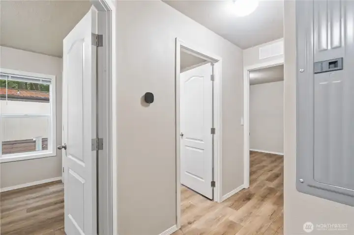 Interior hallway connecting bedrooms, bathroom, & laundry.