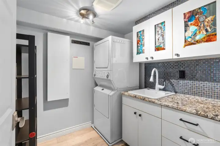 Laundry room featuring a utility sink, a built-in ironing board, and additional storage.