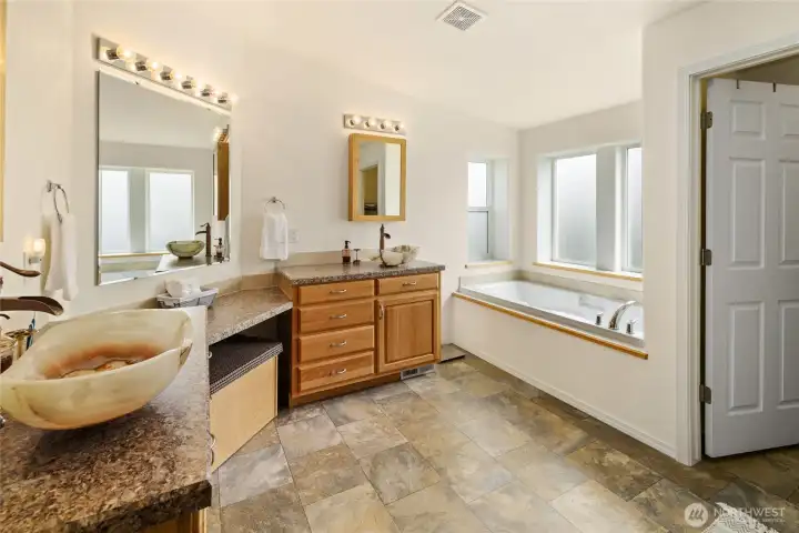 Primary bathroom with double sinks and large soaking tub.