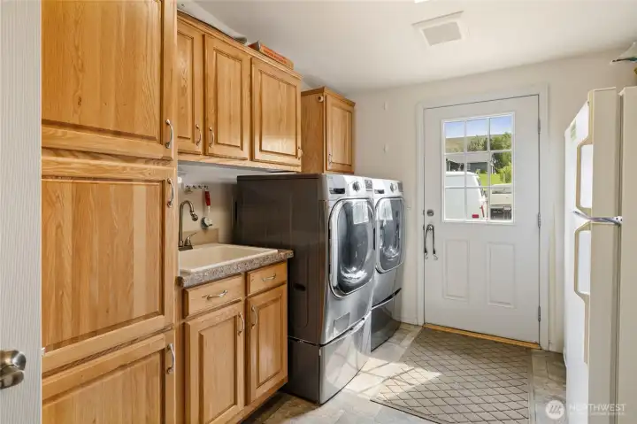 Laundry room includes the washer and dryer. The washer has and extra washing drawer below.