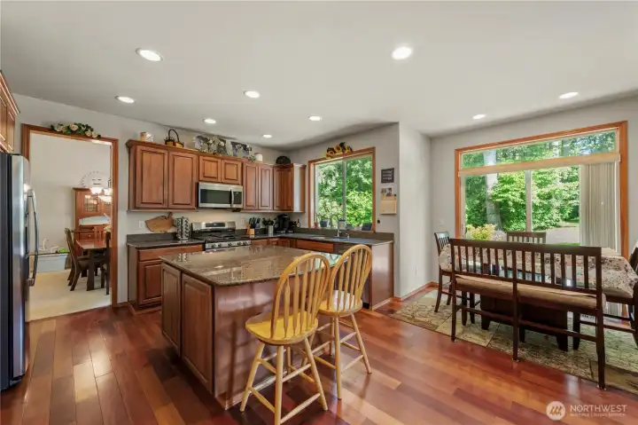Friends hang out at the island and the breakfast nook while you check when dinner is ready.
