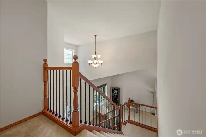 Vaulted entry and warm wood railing set the tone even just for coming down to breakfast.