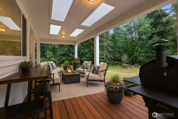 Designed for year-round enjoyment, the spectacular wraparound covered deck is an outdoor living space you'll never want to leave. Blurring the line between indoor and outdoor living, this expansive retreat offers an exceptional setting for entertaining, dining, or simply unwinding in nature. Whether hosting summer barbecues, gathering around the fire table, or savoring a quiet morning coffee surrounded by towering evergreens, this inviting outdoor sanctuary offers exceptional comfort, privacy, and a seamless connection to the peaceful beauty of the Pacific Northwest. Designed for year-round enjoyment, the spectacular wraparound covered deck is an outdoor living space you'll never want to leave. Blurring the line between indoor and outdoor living, this expansive retreat offers an exceptional setting for entertaining, dining, or simply unwinding in nature. Whether hosting summer barbecues, gathering around the fire table, or savoring a quiet morning coffee surrounded by towering evergreens, this inviting outdoor sanctuary offers exceptional comfort, privacy, and a seamless connection to the peaceful beauty of the Pacific Northwest.