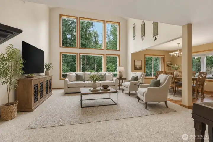 A truly breathtaking vaulted great room makes an unforgettable first impression, where soaring ceilings and a spectacular wall of glass create a dramatic showcase of the surrounding woodland. Bathed in natural light, this magnificent space seamlessly blends architectural grandeur with the serenity of nature. A striking gas fireplace with an elegant black mantel anchors the room, while updated plush carpeting with premium moisture-resistant memory foam-style padding adds exceptional comfort and warmth underfoot. Whether enjoying a quiet morning as sunlight pours through the towering windows or entertaining beneath the soaring ceilings, this extraordinary great room is designed to inspire and impress. A truly breathtaking vaulted great room makes an unforgettable first impression, where soaring ceilings and a spectacular wall of glass create a dramatic showcase of the surrounding woodland. Bathed in natural light, this magnificent space seamlessly blends architectural grandeur with the serenity of nature. A striking gas fireplace with an elegant black mantel anchors the room, while updated plush carpeting with premium moisture-resistant memory foam-style padding adds exceptional comfort and warmth underfoot. Whether enjoying a quiet morning as sunlight pours through the towering windows or entertaining beneath the soaring ceilings, this extraordinary great room is designed to inspire and impress.