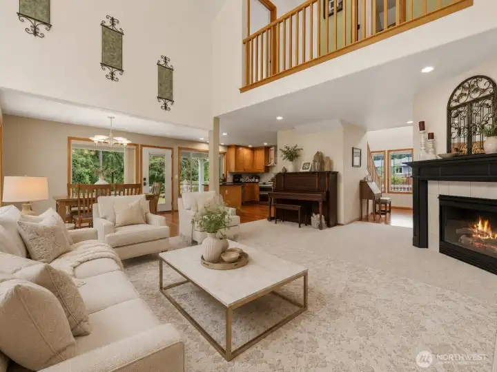 This spacious great room makes a beautiful first impression with soaring ceilings, expansive windows, and a warm fireplace that anchors the living space. The open-concept design flows effortlessly into the dining area and kitchen, creating a comfortable layout for everyday living and entertaining. Soft natural light, peaceful views of the surrounding greenery, and the upper-level overlook add to the airy, inviting feel, while the fireplace and generous gathering areas make this the perfect place to relax, host, and enjoy home. This spacious great room makes a beautiful first impression with soaring ceilings, expansive windows, and a warm fireplace that anchors the living space. The open-concept design flows effortlessly into the dining area and kitchen, creating a comfortable layout for everyday living and entertaining. Soft natural light, peaceful views of the surrounding greenery, and the upper-level overlook add to the airy, inviting feel, while the fireplace and generous gathering areas make this the perfect place to relax, host, and enjoy home.