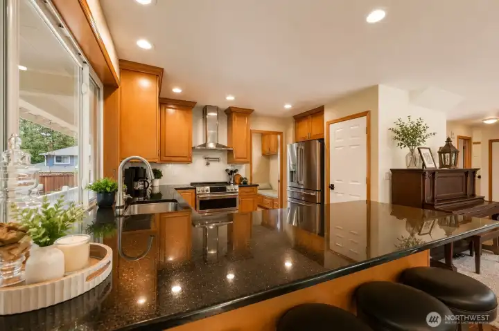 The heart of the home, this spectacular chef-inspired kitchen is designed to bring people together. An expansive granite island with breakfast bar seating anchors the space, surrounded by rich wood cabinetry, premium GE Café Series smart appliances, a 4-door French door refrigerator, 30" Smart Slide-In Double Convection Oven, ultra-quiet 44 dBA dishwasher, striking stainless steel hood, designer tile backsplash, and a convenient pot filler. Flooded with natural light and seamlessly open to the great room and dining area, this exceptional kitchen blends luxury, functionality, and effortless entertaining. The heart of the home, this spectacular chef-inspired kitchen is designed to bring people together. An expansive granite island with breakfast bar seating anchors the space, surrounded by rich wood cabinetry, premium GE Café Series smart appliances, a 4-door French door refrigerator, 30" Smart Slide-In Double Convection Oven, ultra-quiet 44 dBA dishwasher, striking stainless steel hood, designer tile backsplash, and a convenient pot filler. Flooded with natural light and seamlessly open to the great room and dining area, this exceptional kitchen blends luxury, functionality, and effortless entertaining.