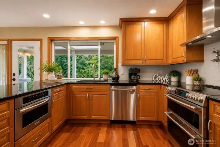 Prepare to fall in love with this spectacular chef-inspired kitchen, where timeless elegance meets modern convenience. Rich wood cabinetry, polished granite countertops, gleaming hardwood floors, and premium GE Café Series smart appliances—including a 4-door French door refrigerator, 30" Smart Slide-In Double Convection Oven, and an ultra-quiet 44 dBA dishwasher—create a space that's as beautiful as it is functional. A striking stainless steel hood, convenient pot filler, designer tile backsplash, spacious walk-in pantry, and expansive island with bar seating make this kitchen the perfect setting for everyday living and effortless entertaining. Prepare to fall in love with this spectacular chef-inspired kitchen, where timeless elegance meets modern convenience. Rich wood cabinetry, polished granite countertops, gleaming hardwood floors, and premium GE Café Series smart appliances—including a 4-door French door refrigerator, 30" Smart Slide-In Double Convection Oven, and an ultra-quiet 44 dBA dishwasher—create a space that's as beautiful as it is functional. A striking stainless steel hood, convenient pot filler, designer tile backsplash, spacious walk-in pantry, and expansive island with bar seating make this kitchen the perfect setting for everyday living and effortless entertaining.