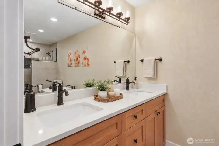 Every detail of the luxurious primary bath has been thoughtfully curated to create a true sanctuary. Newly updated luxury vinyl plank flooring enhances the warm, sophisticated design, while the elegant freestanding soaking tub invites you to unwind and the expansive walk-in ceramic tile shower with frameless glass offers a spa-like experience. Gleaming quartz countertops, custom wood cabinetry, and designer oil-rubbed bronze Moen Belfield fixtures complete this beautifully remodeled retreat, offering the perfect blend of timeless elegance, comfort, and everyday indulgence. Every detail of the luxurious primary bath has been thoughtfully curated to create a true sanctuary. Newly updated luxury vinyl plank flooring enhances the warm, sophisticated design, while the elegant freestanding soaking tub invites you to unwind and the expansive walk-in ceramic tile shower with frameless glass offers a spa-like experience. Gleaming quartz countertops, custom wood cabinetry, and designer oil-rubbed bronze Moen Belfield fixtures complete this beautifully remodeled retreat, offering the perfect blend of timeless elegance, comfort, and everyday indulgence.