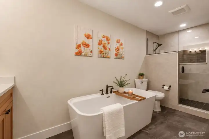 Retreat to the beautifully remodeled primary ensuite, where spa-inspired luxury awaits. Newly updated luxury vinyl plank flooring sets the stage for this elegant retreat, featuring a freestanding soaking tub perfect for unwinding and an expansive walk-in ceramic tile shower with a sleek frameless glass enclosure. Rich wood cabinetry is topped with gleaming quartz countertops and complemented by designer oil-rubbed bronze Moen Belfield fixtures, creating a warm, timeless aesthetic. Every detail has been thoughtfully selected to deliver the perfect blend of sophistication, comfort, and everyday indulgence. Retreat to the beautifully remodeled primary ensuite, where spa-inspired luxury awaits. Newly updated luxury vinyl plank flooring sets the stage for this elegant retreat, featuring a freestanding soaking tub perfect for unwinding and an expansive walk-in ceramic tile shower with a sleek frameless glass enclosure. Rich wood cabinetry is topped with gleaming quartz countertops and complemented by designer oil-rubbed bronze Moen Belfield fixtures, creating a warm, timeless aesthetic. Every detail has been thoughtfully selected to deliver the perfect blend of sophistication, comfort, and everyday indulgence.