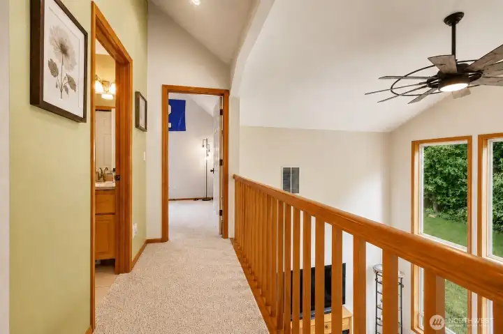 The elegant upper-level overlook adds architectural interest and an open, connected feel throughout the home. Framed by soaring ceilings and expansive windows, this inviting space is enhanced by newer interior paint, updated plush carpeting, and warm wood accents that create a bright, welcoming atmosphere with peaceful views of the surrounding trees. The elegant upper-level overlook adds architectural interest and an open, connected feel throughout the home. Framed by soaring ceilings and expansive windows, this inviting space is enhanced by newer interior paint, updated plush carpeting, and warm wood accents that create a bright, welcoming atmosphere with peaceful views of the surrounding trees.