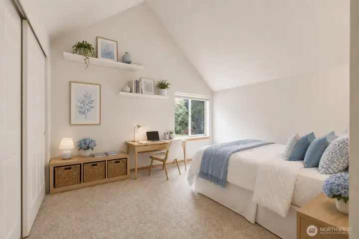 An upper-level bedroom with vaulted ceilings and peaceful views of the surrounding evergreens, creating a flexible retreat that feels bright, and inviting. An upper-level bedroom with vaulted ceilings and peaceful views of the surrounding evergreens, creating a flexible retreat that feels bright, and inviting.