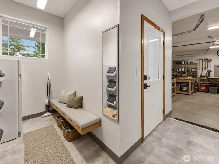 A practical yet inviting mudroom provides convenient access from both the garage and outdoors, creating the perfect drop zone for everyday living. Complete with a built-in bench and ample space to stay organized after outdoor adventures, it seamlessly connects to the oversized garage/workshop, offering exceptional flexibility for tools, hobbies, storage, or DIY projects. An ideal complement to the property's expansive 2.26-acre setting, there's plenty of room to enjoy both work and play. Garage has workbench with built in cabinetry. A practical yet inviting mudroom provides convenient access from both the garage and outdoors, creating the perfect drop zone for everyday living. Complete with a built-in bench and ample space to stay organized after outdoor adventures, it seamlessly connects to the oversized garage/workshop, offering exceptional flexibility for tools, hobbies, storage, or DIY projects. An ideal complement to the property's expansive 2.26-acre setting, there's plenty of room to enjoy both work and play. Garage has workbench with built in cabinetry.