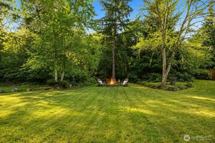 At the edge of the expansive park-like lawn, a private fire pit is tucked beneath a canopy of towering evergreens, creating the perfect gathering place for family and friends. Surrounded by lush landscaping, native ferns, and the peaceful sounds of nature, this secluded retreat invites memorable evenings under the stars and a lifestyle defined by privacy, tranquility, and the timeless beauty of the Pacific Northwest. Imagine ending each day gathered around the fire beneath a canopy of majestic evergreens, where the only soundtrack is birdsong and the gentle rustle of the forest. At the edge of the expansive park-like lawn, a private fire pit is tucked beneath a canopy of towering evergreens, creating the perfect gathering place for family and friends. Surrounded by lush landscaping, native ferns, and the peaceful sounds of nature, this secluded retreat invites memorable evenings under the stars and a lifestyle defined by privacy, tranquility, and the timeless beauty of the Pacific Northwest. Imagine ending each day gathered around the fire beneath a canopy of majestic evergreens, where the only soundtrack is birdsong and the gentle rustle of the forest.