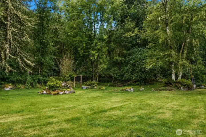 Step beyond the wraparound covered deck into your own private woodland sanctuary. Expansive lawns give way to towering evergreens, native ferns, moss-covered boulders, and seasonal wildflowers, creating a landscape that feels both breathtaking and timeless. Wrapped in nature and serenaded by birdsong, this peaceful retreat offers exceptional privacy and endless opportunities to garden, explore, entertain, or simply unwind beneath the trees. More than a backyard, it's a rare connection to the beauty and tranquility of the Pacific Northwest. Step beyond the wraparound covered deck into your own private woodland sanctuary. Expansive lawns give way to towering evergreens, native ferns, moss-covered boulders, and seasonal wildflowers, creating a landscape that feels both breathtaking and timeless. Wrapped in nature and serenaded by birdsong, this peaceful retreat offers exceptional privacy and endless opportunities to garden, explore, entertain, or simply unwind beneath the trees. More than a backyard, it's a rare connection to the beauty and tranquility of the Pacific Northwest.