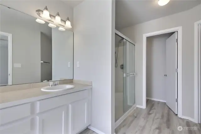 Capture the view of the primary stand-up shower, accompanied by an adjacent discreet door leading to the private toilet room, offering convenience and privacy. Additionally, the spacious walk-in closet stands ready to accommodate your wardrobe needs, completing the picture of comfort and functionality.