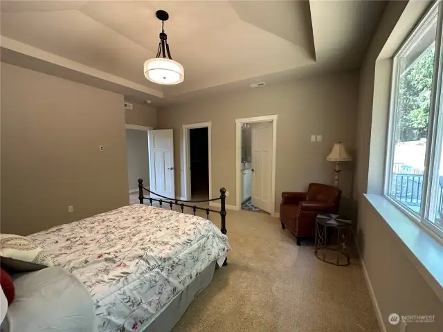 Primary bedroom with custom coffered ceiling, sitting area, large closet and private bathroom.