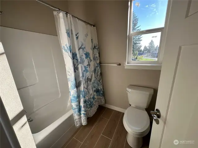 Main bath with separation of tub and commode.