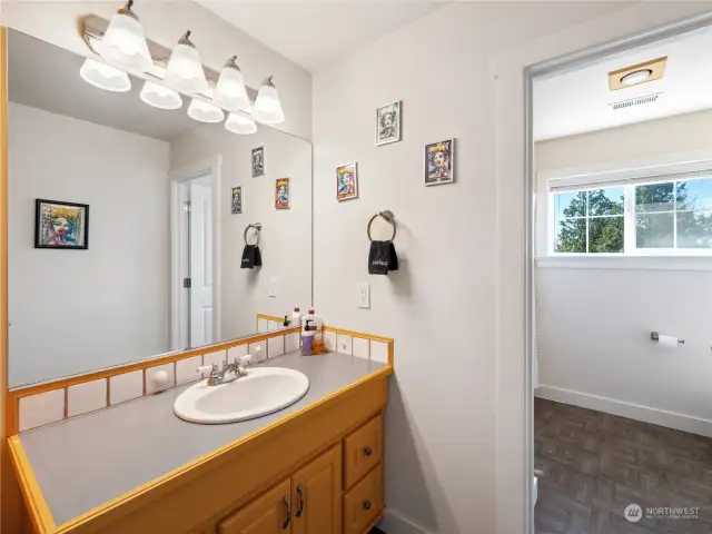 Upstairs bathroom is conveniently separated into 2 spaces - the vanity/sink and linen closet and a door to the shower/tub and commode.