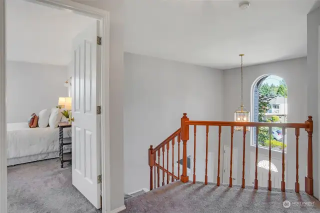 Upstairs landing looking out to the two-story foyer and pretty window.