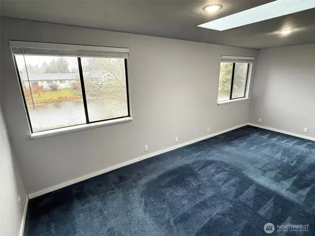 Primary bedroom on the upper level with views of the canal.