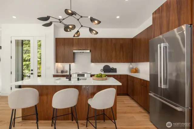 Warm walnut cabinetry, calcatta premata quartz and stacked porcelain backsplash compliment the kitchen's sleek, modern feel.