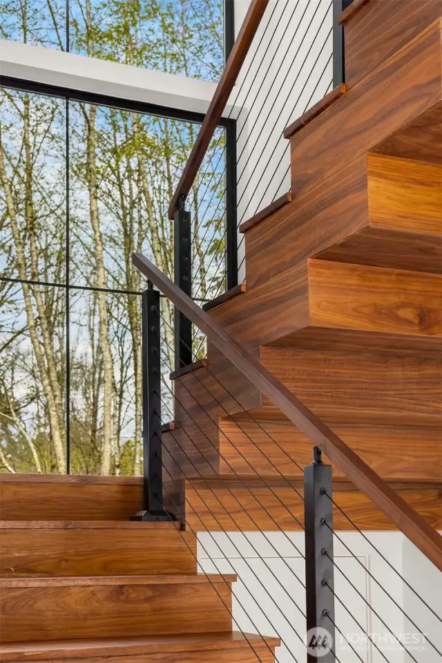 A work of art. Escher inspired, walnut wrapped staircase with floor to ceiling windows and steel cable and walnut railing.