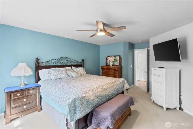 Large primary bedroom has a walk-in closet, ensuite and deck access through sliding doors.