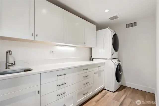 A barn-style door allows the media/family room and upper second primary suite to become a private retreat. Complete with laundry facilities, generous storage, sink, Sub-Zero refrigerator, and beverage fridge, the space is both functional and luxurious.