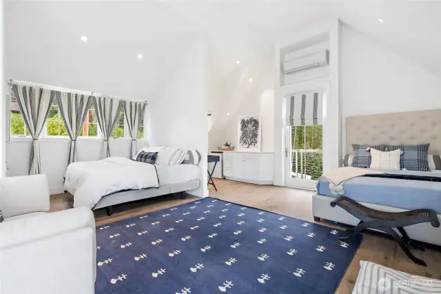 The second primary suite is crowned with vaulted ceilings and opens to serene water views, while a Juliette balcony offers a graceful perch above the gardens and lawn.