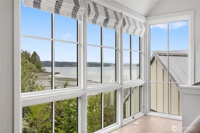 The second primary suite enjoys serene water views.