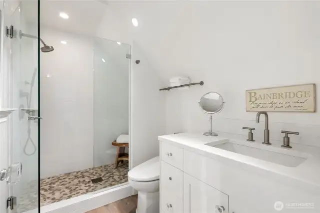 Vaulted ceilings and a tiled shower give the 3/4 bath a bright, refined feel.