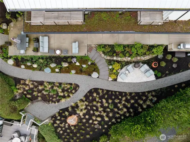 Thoughtful landscaping blends beauty and function with water features, pathways, abundant seating, and edible gardens—all in harmony with shoreline guidelines.
