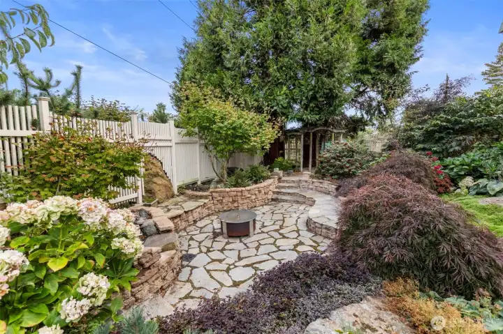 One amazing feature of the lush grounds is the sunken fire pit and stone seating. Cleverly incorporated in to the native plant species, this private hollow could seat over a dozen, with easy access to the kitchen area. Entirely private from the street and neighboring homes, you feel immersed in the mature natural setting.