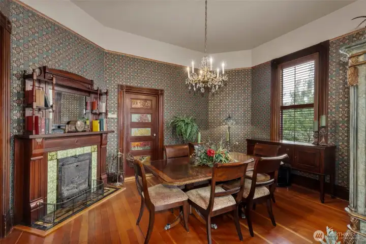 From the living room and through the double disappearing sliding doors is the formal dining room. A functional (though seldom used) wood burning fireplace and victorian mantle are the centerpiece in this gorgeous room. Again, the large pane windows and stunning views of the grounds seem to draw the outdoors, in. a ‘servers’ door to the kitchen sits near the back of the large room.