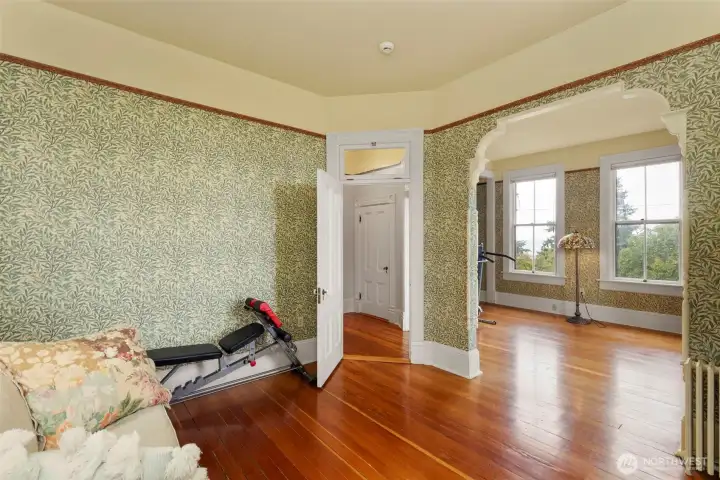 The main Bedroom just at the top of the stairsway. Spanning the width of the home and commanding a fantastic view of the surroundings, this space has VG Fir flooring and period appropriate fixtures and wall finishings, as does the entire home.