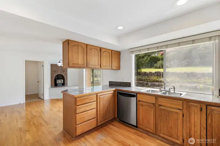 Kitchen from a different angle, showing breakfast area, laundry room dor, and family room. Kitchen window overlooks back patio