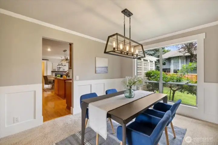 Formal dining room with newer lighting and big window looking out to the backyard.