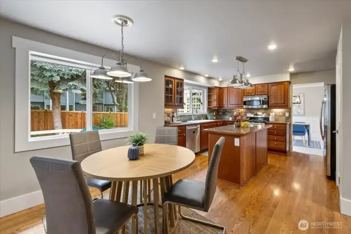 Kitchen eating area with nice lighting and window looking out to the backyard.