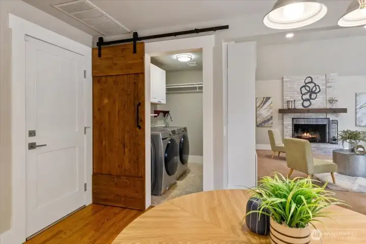 Laundry room with nice washer and dryer, and stylish barn door adding some nice warmth and character.