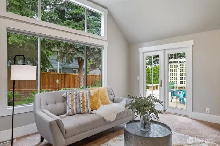 Large window with great lighting and pretty backyard to look at along with French doors leading to the deck.