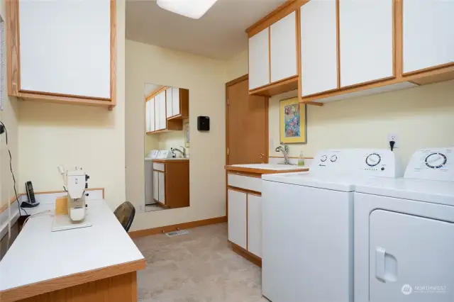 Side A- Utility room w/door to garage boasts built-in sewing/folding station & ample storage. W/D stay w/home