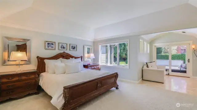 Spacious primary suite is light and bright with high tray ceiling, large window and formal white millwork.