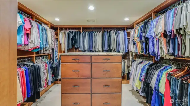 Large custom closet with island dresser topped with granite.