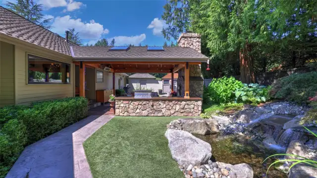 Garden shed located at side yard. Artificial turf along waterfall.