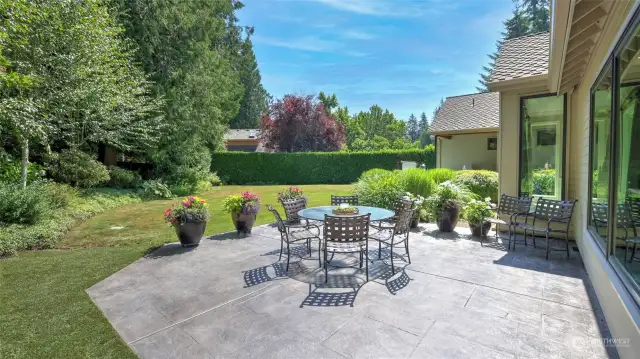 Stamped concrete patio is surrounded by lush trees and native foliage. Perfect for Al fresco dining!