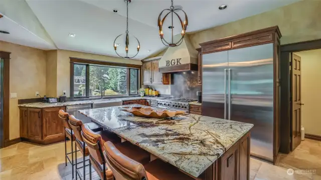 Stunning kitchen features Canyon Creek rustic alder cabinets, granite island and counters, top-of-the-line Subzero and Wolf appliances and heated travertine floors.