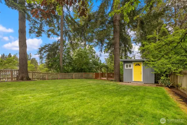 Fully-fenced yard with adorable storage shed