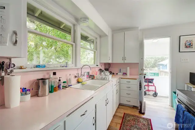 Galley kitchen with large windows.