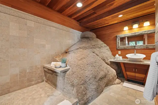 The 3/4 bath on the lake level has the rock protruding into the room as part of the large, tiled shower.