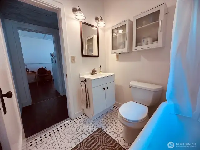 Main bathroom with fresher vanity, tile floors, and claw foot tub.